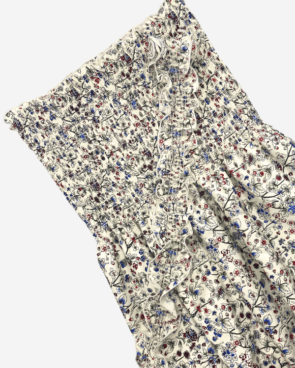 Pre-smocked cream floral fabric detail showing pearl edge and ruffled top