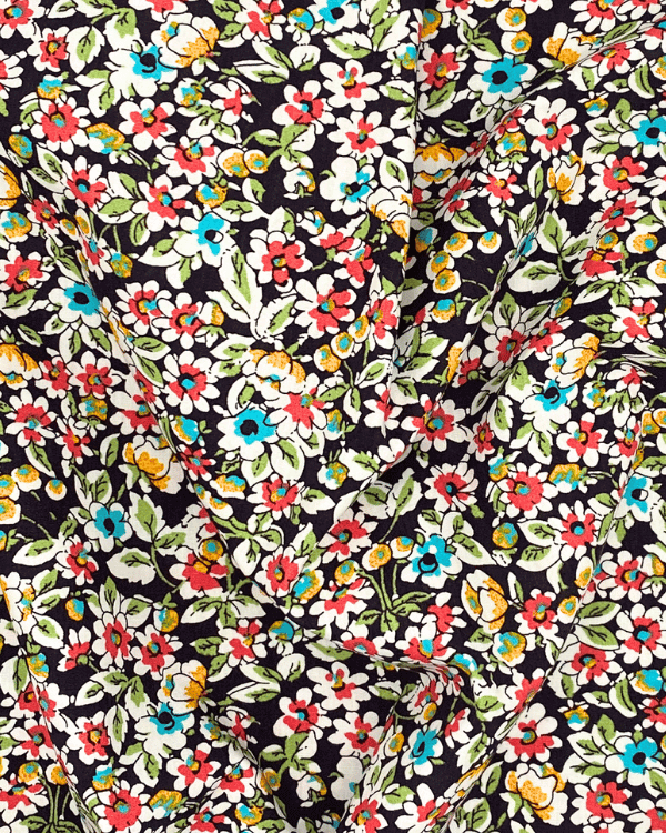 Brown ditsy floral cotton fabric draped to show vintage inspired small-scale flower print in aqua, coral, mustard and white.