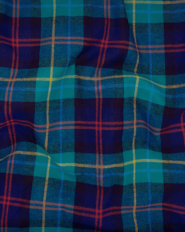 Soft green and navy brushed cotton flannel fabric shown with natural folds – plaid pattern with red and yellow accents