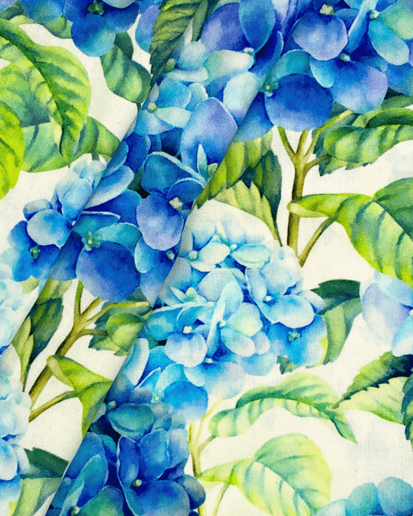 Botanical blue floral rayon fabric folded to show detailed watercolor-style hydrangea print
