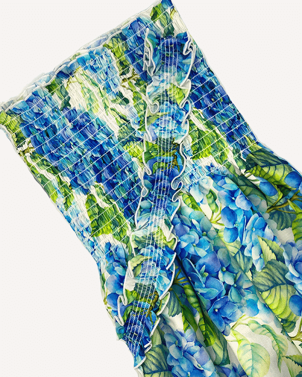 Close-up of smocked rayon fabric with bold blue and green floral print.