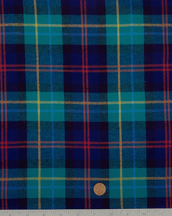 Green and navy plaid cotton flannel fabric with ruler and penny for scale – 58 inches wide