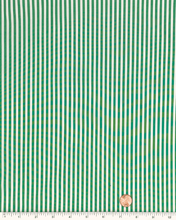 Green and white striped cotton fabric with ruler and penny for scale