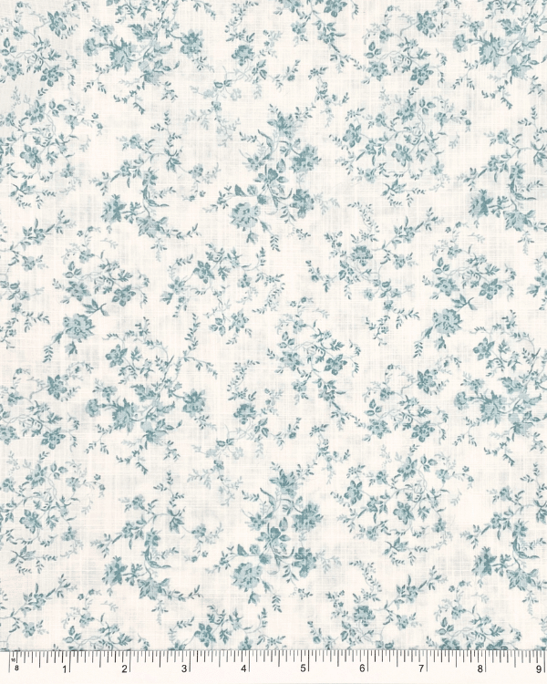 Vintage-inspired green floral cotton slub fabric with hints of light blue, ruler for scale, 58 inches wide, lightweight and breathable fabric for sewing projects