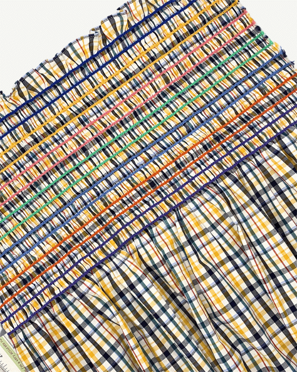 Yellow navy plaid shirred cotton fabric close-up with elastic smocking