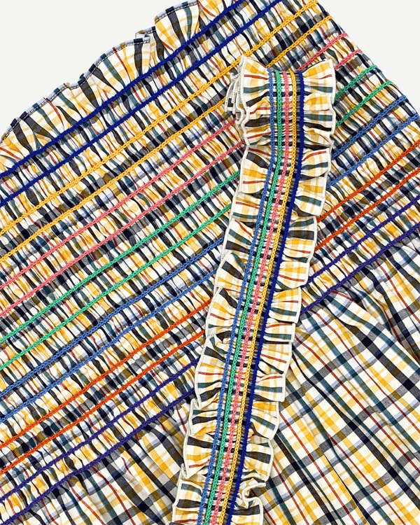 Smocked plaid dress fabric shown with ruffled strap detail